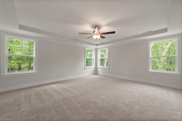 carpeted empty room featuring ceiling fan and a tray ceiling