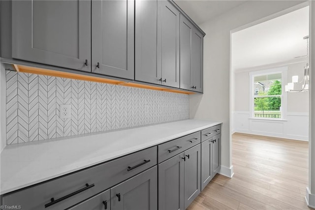 kitchen with light hardwood / wood-style flooring, tasteful backsplash, and gray cabinets