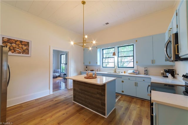 301 S Shaver St, Salisbury, NC 28144 - kitchen featuring stainless steel appliances, blue cabinetry, healthy amount of natural light, and light wood-style floors