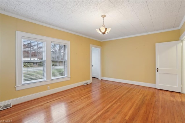 1146 Rogers Rd, Graham, NC 27253 - spare room with light wood-style floors, ornamental molding, baseboards, and a chandelier