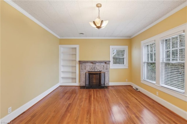1146 Rogers Rd, Graham, NC 27253 - unfurnished living room featuring ornamental molding, a fireplace, light wood-type flooring, built in shelves, and baseboards