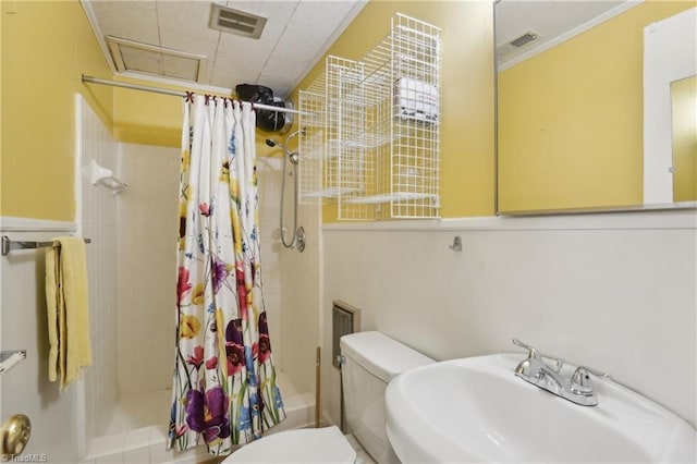 1146 Rogers Rd, Graham, NC 27253 - bathroom featuring a sink, toilet, a tile shower, and ornamental molding