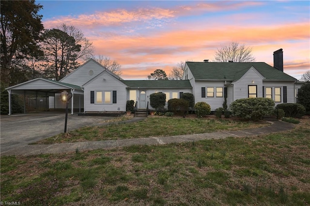 1146 Rogers Rd, Graham, NC 27253 - view of front facade featuring a chimney, a yard, driveway, and a carport