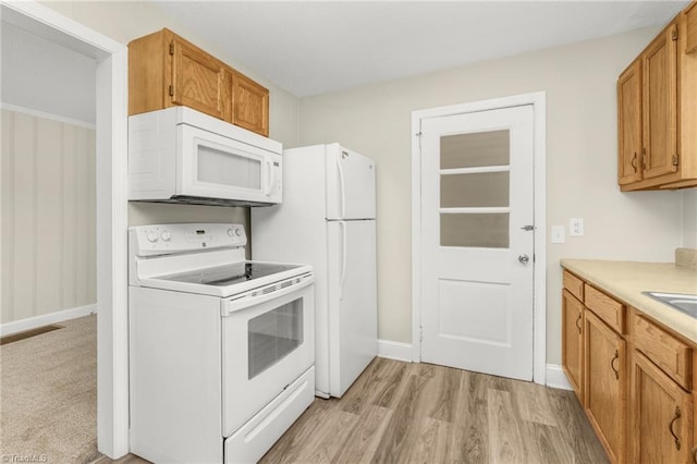 225 Harper St, Winston-Salem, NC 27104 - kitchen featuring white appliances, light countertops, brown cabinetry, and light wood-style floors