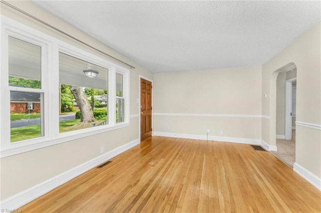 225 Harper St, Winston-Salem, NC 27104 - empty room featuring arched walkways, light wood finished floors, and healthy amount of natural light