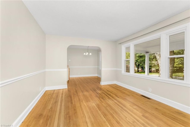 225 Harper St, Winston-Salem, NC 27104 - spare room with arched walkways, light wood finished floors, and a chandelier