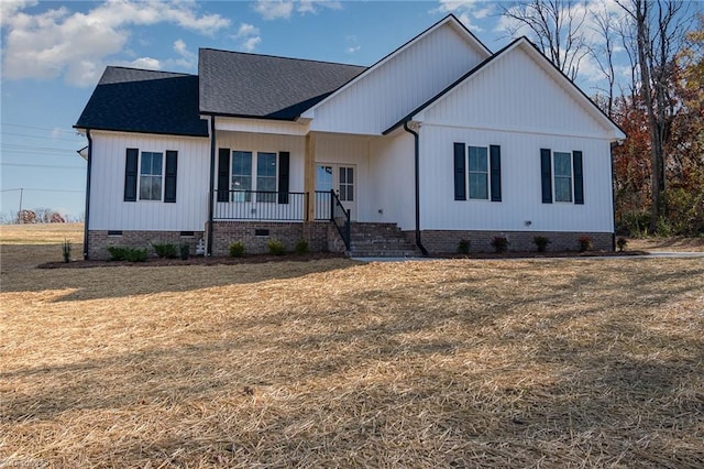 modern farmhouse featuring a front yard and covered porch