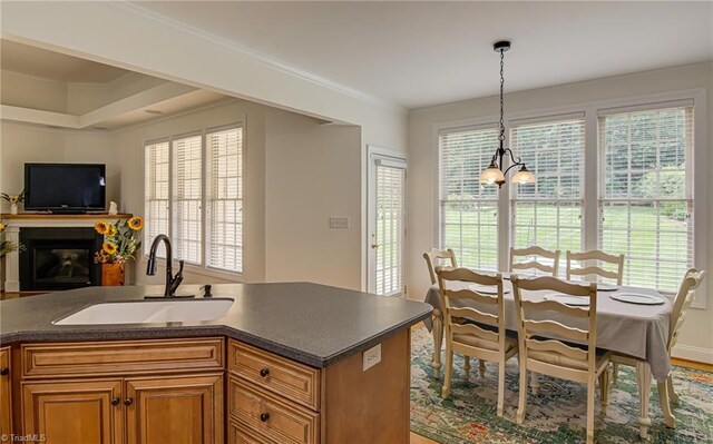 160 Serenity Pointe Dr, Kernersville, NC 27284 - kitchen with dark countertops, open floor plan, pendant lighting, brown cabinetry, and a glass covered fireplace