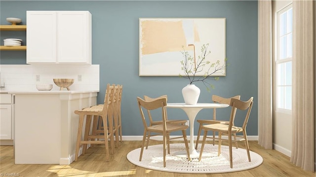 dining space with light wood-style floors and baseboards