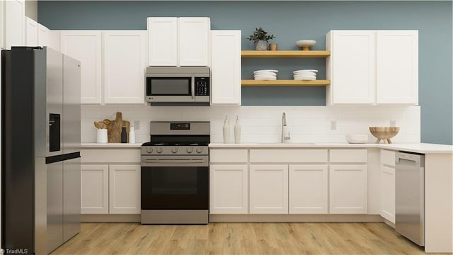 kitchen featuring backsplash, appliances with stainless steel finishes, light countertops, and a sink