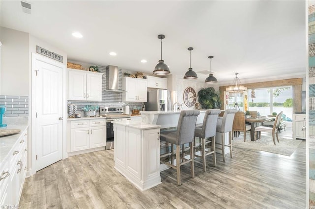 440 Sportsman Dr, Salisbury, NC 28146 - kitchen with a breakfast bar, stainless steel appliances, light countertops, wall chimney range hood, and backsplash