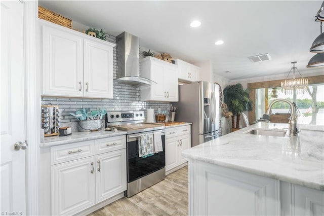 440 Sportsman Dr, Salisbury, NC 28146 - kitchen featuring wall chimney range hood, white cabinets, a sink, visible vents, and stainless steel appliances