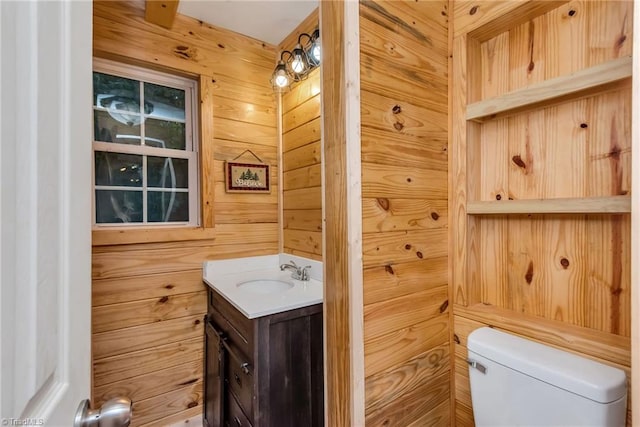 bathroom with wood walls, vanity, and toilet