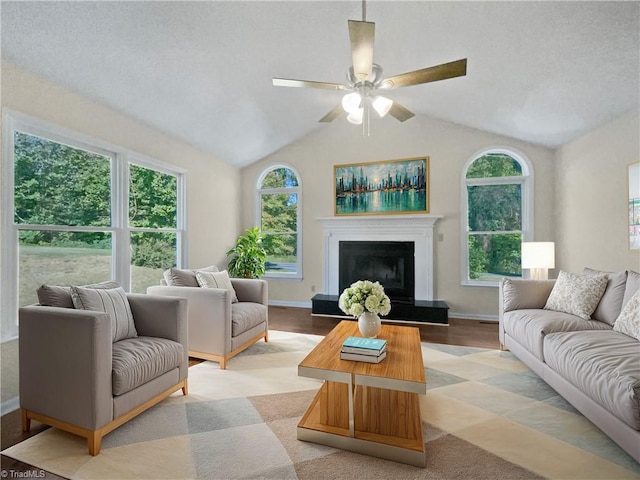 living room with lofted ceiling, ceiling fan, light hardwood / wood-style floors, and a textured ceiling