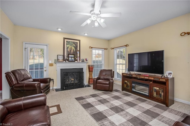 living room with carpet flooring, ceiling fan, and a healthy amount of sunlight