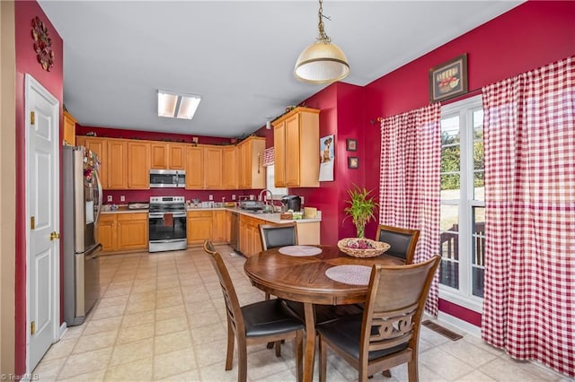 kitchen featuring sink, pendant lighting, and appliances with stainless steel finishes