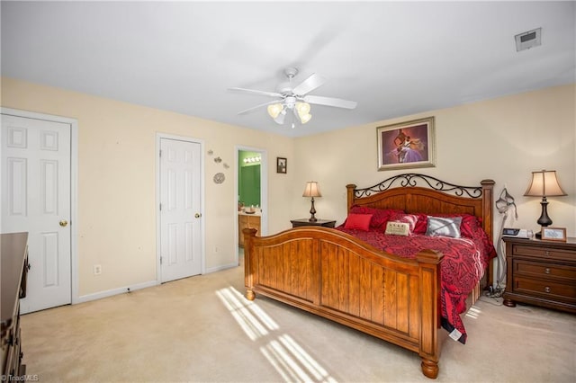 carpeted bedroom with ceiling fan and ensuite bath