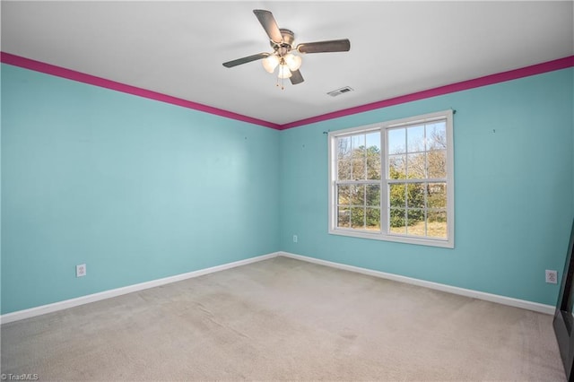 carpeted spare room featuring ceiling fan