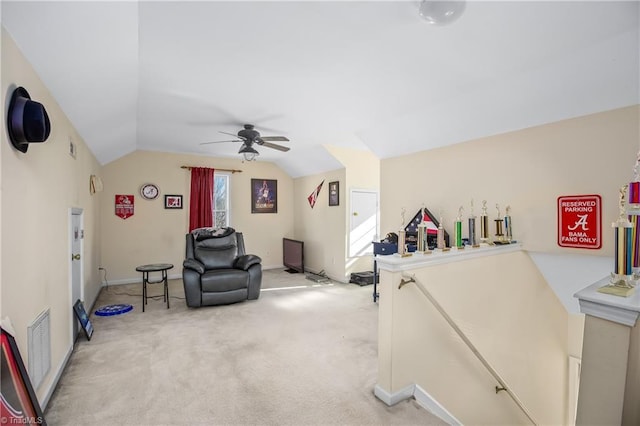 living area with carpet floors, vaulted ceiling, and ceiling fan