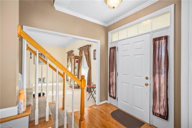 entrance foyer with ornamental molding and light hardwood / wood-style flooring