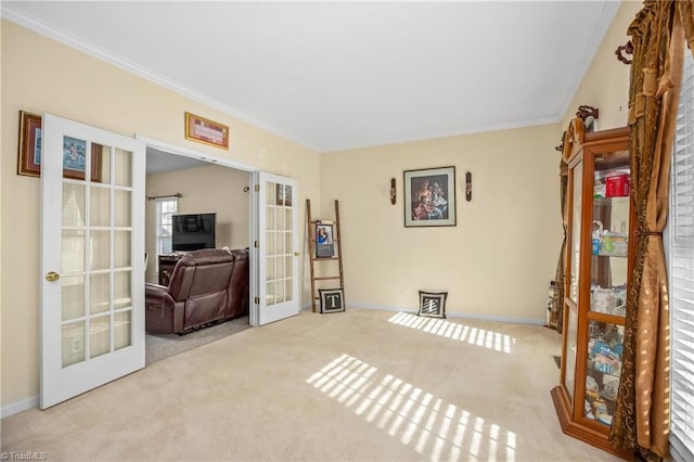 interior space with crown molding, french doors, and light colored carpet