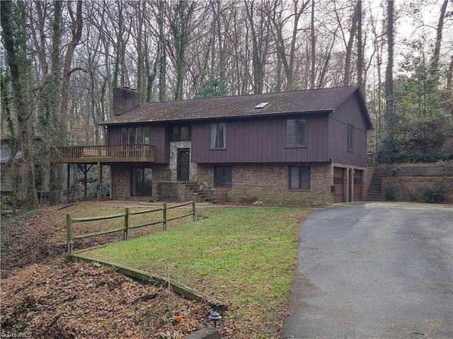 raised ranch featuring a front lawn and a garage