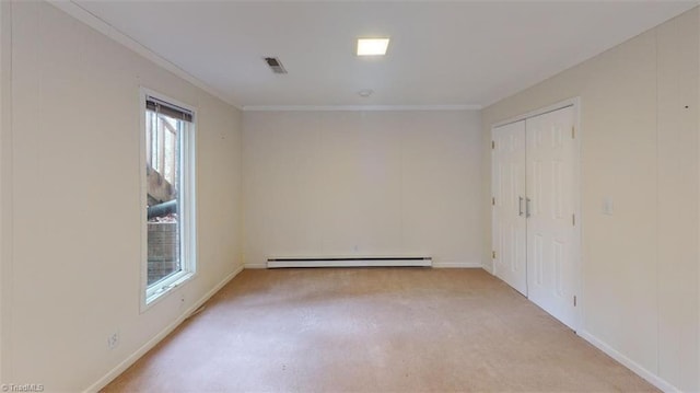 carpeted spare room with crown molding and a baseboard radiator