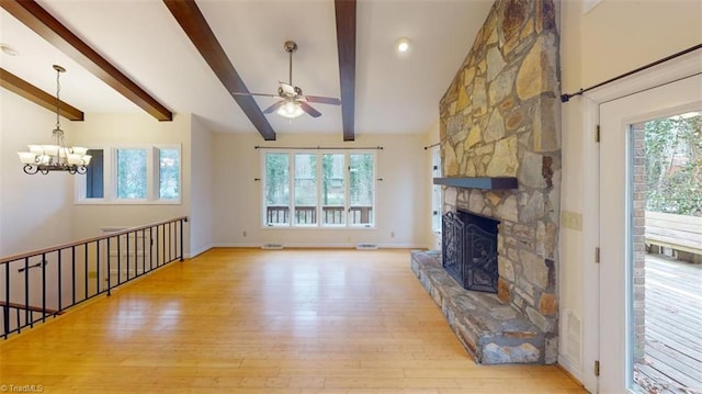 unfurnished living room with lofted ceiling with beams, light wood-type flooring, a fireplace, and ceiling fan with notable chandelier