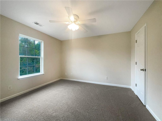 spare room featuring ceiling fan and dark carpet