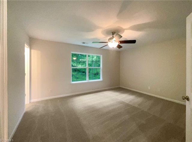 carpeted spare room with ceiling fan