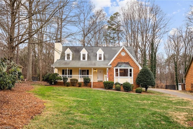 new england style home with covered porch and a front yard