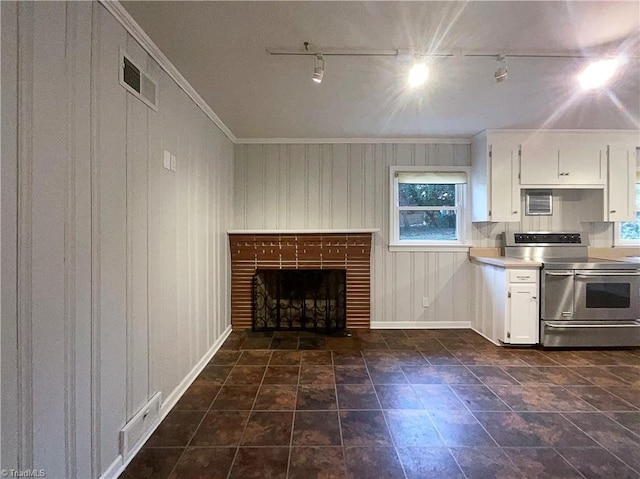 kitchen with range with two ovens, a fireplace, visible vents, white cabinets, and light countertops