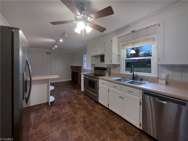 kitchen with white cabinets, stainless steel appliances, a sink, and light countertops