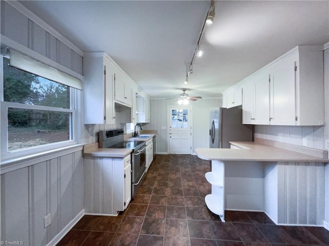 kitchen featuring appliances with stainless steel finishes, plenty of natural light, white cabinetry, and a sink