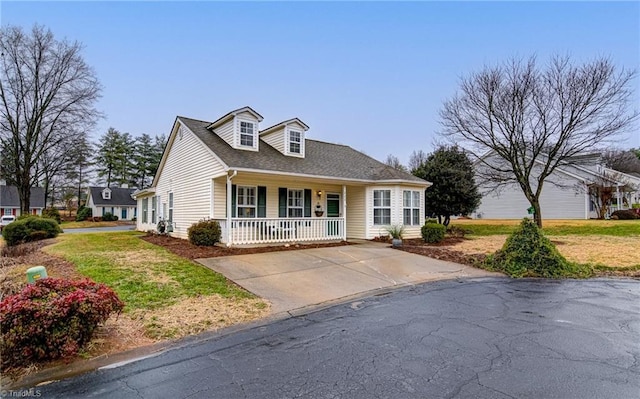 new england style home featuring covered porch and a front yard