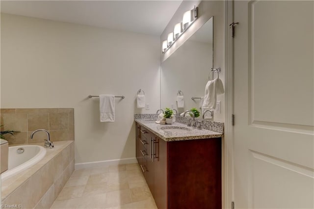 bathroom with a sink, double vanity, tile patterned floors, baseboards, and a bath