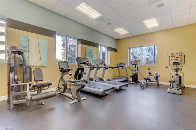 workout area with baseboards and a drop ceiling