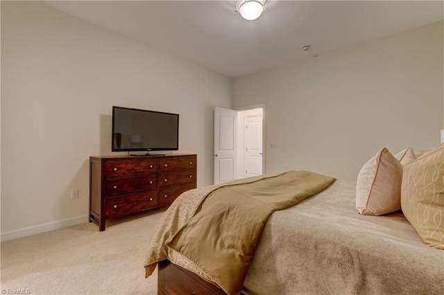bedroom featuring baseboards and light carpet