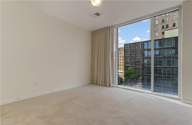 unfurnished room featuring visible vents, carpet flooring, and a healthy amount of sunlight