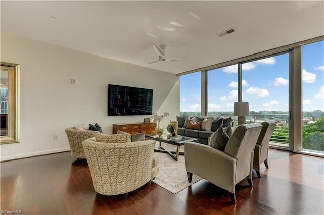 living room featuring a ceiling fan, dark wood finished floors, expansive windows, and visible vents