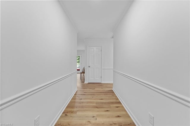 hallway with crown molding and light hardwood / wood-style floors