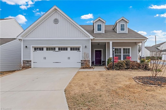 view of front of home featuring a garage, a porch, and a front lawn