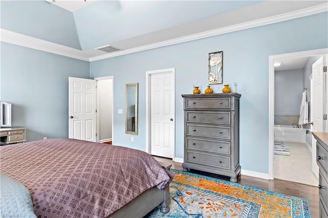 bedroom with crown molding, connected bathroom, and dark hardwood / wood-style flooring