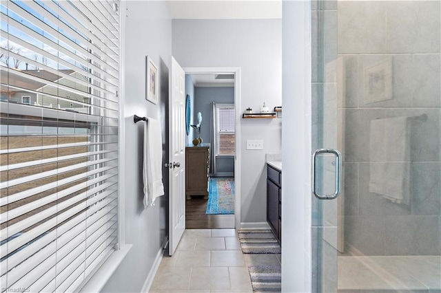 bathroom with walk in shower, vanity, and tile patterned flooring