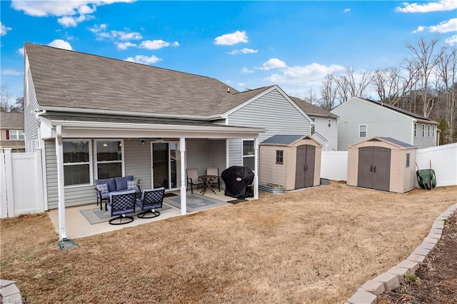 back of property with a storage shed, an outdoor living space, and a patio