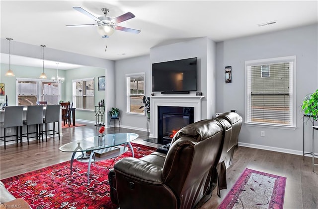 living room featuring ceiling fan with notable chandelier and hardwood / wood-style floors