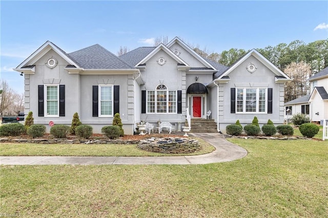 view of front of property featuring stucco siding, roof with shingles, and a front lawn