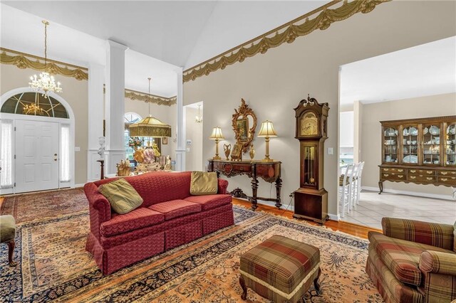 living room with high vaulted ceiling, baseboards, and a chandelier