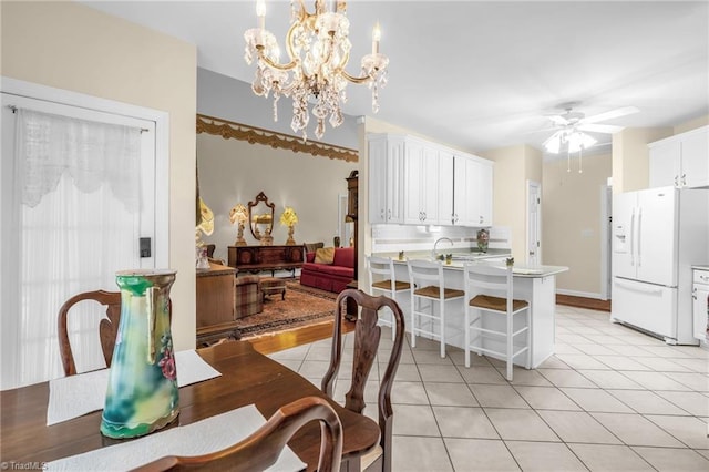 dining space featuring light tile patterned floors, baseboards, and ceiling fan with notable chandelier