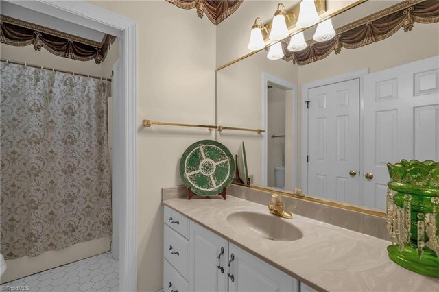 bathroom with vanity, tile patterned floors, toilet, and shower / tub combo with curtain